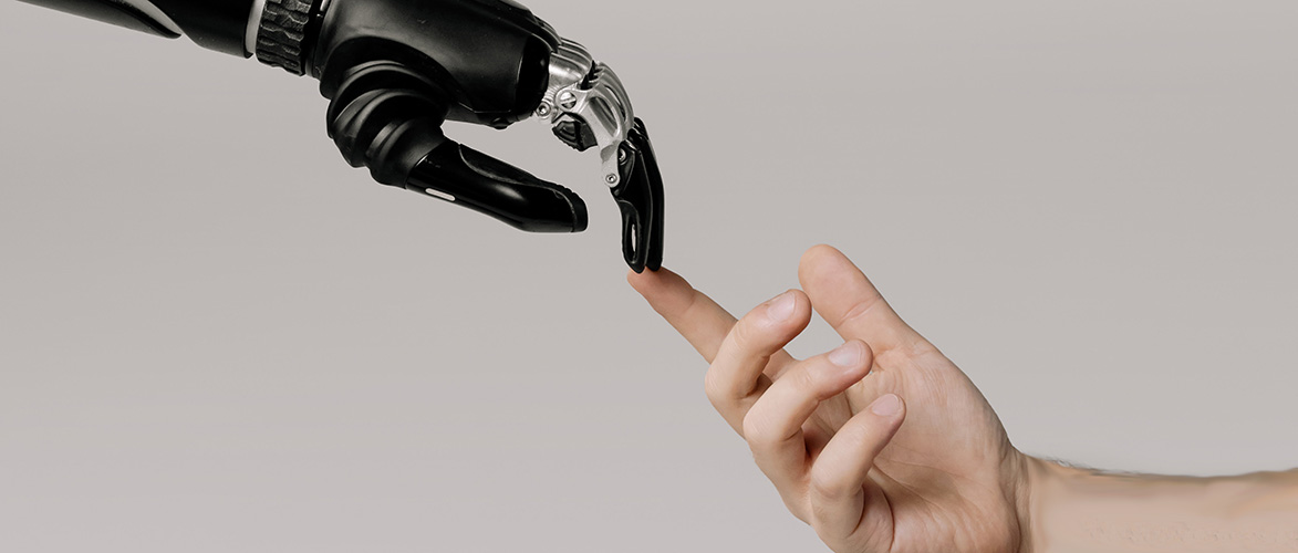 KI am Arbeitsplatz - Menschliche Hand und Roboterhand berühren sich