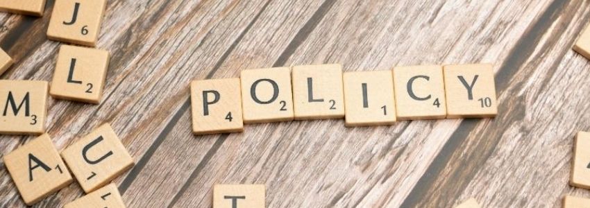 Das Wort "Policy auf Spielsteinen dargestellt. 