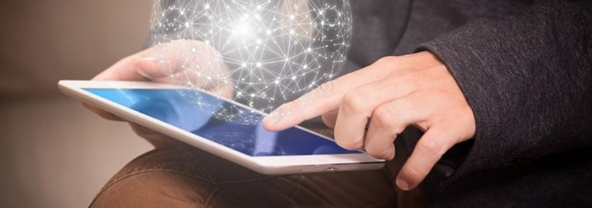 Person mit Tablet in der Hand über dem ein Netzwerk schwebt
