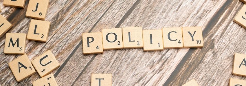 Das Wort "Policy auf Spielsteinen dargestellt. 
